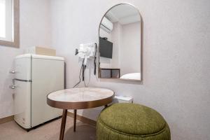 a room with a small table and a mirror and a refrigerator at the stay in Seoul