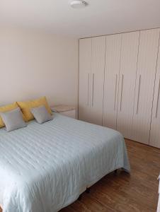 a bedroom with a large white bed and white cabinets at Casa para disfrutar en Necochea 5 personas in Necochea