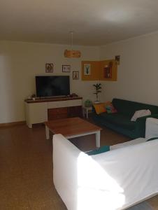 ein Wohnzimmer mit Sofa und Fernseher in der Unterkunft Casa para disfrutar en Necochea 5 personas in Necochea