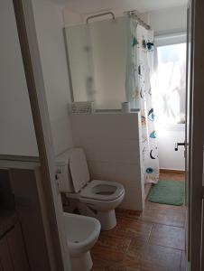 a small bathroom with a toilet and a shower at Casa para disfrutar en Necochea 5 personas in Necochea +8 photos