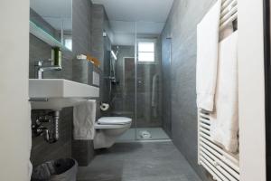 Un baño con inodoro, lavabo y ducha. en Hotel R5 Budget - Chur, en Chur 37 fotos más
