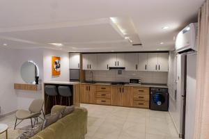 Una sala de estar con un sofá y una cocina. en Atelier Lux Homes- Modern Service Apartments with Amazing Designs, en Ibadán