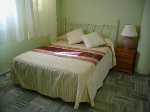 una camera con letto e lampada su comodino di Escudo de Granada a Puerto-López