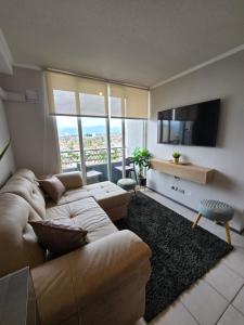 ein Wohnzimmer mit Couch und Flachbildfernseher in der Unterkunft Departamento Céntrico 2 o 3 dorm con Parckin Piscina y Wifi in Rancagua