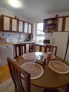 eine Küche mit einem Holztisch mit Tellern darauf in der Unterkunft Apartman BRKO in Bihać