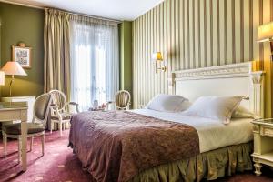 a bedroom with a large bed and a desk at Hotel Regence Paris in Paris