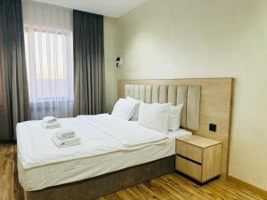 Horizon Hotel في طشقند: غرفة نوم بها سرير كبير عليه منشفتين +12 صورة