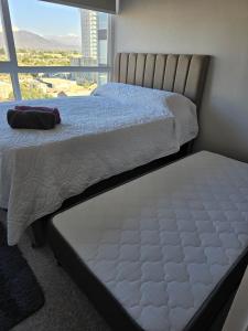 ein Schlafzimmer mit zwei Betten und einem großen Fenster in der Unterkunft Departamento Céntrico 2 o 3 dorm con Parckin Piscina y Wifi in Rancagua