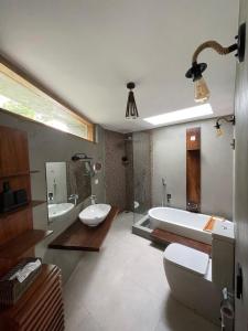 a large bathroom with a tub and a sink and a tub at SereneVbes - Kandy in Kandy
