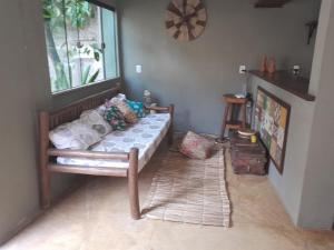 a bedroom with a bed and a window and a rug at Casa hibiscus in Itacaré