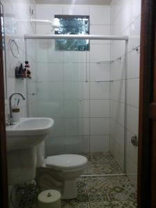 a bathroom with a toilet and a sink at Casa hibiscus in Itacaré