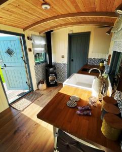 a kitchen with a sink and a stove in a room at Cornwall Shepherds Hut - Hot Tub & Cosy Log Burner in Saint Day +17 photos