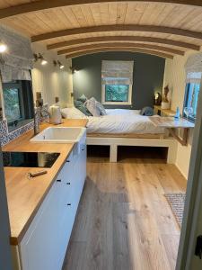 a kitchen with a bed and a sink in a room at Cornwall Shepherds Hut - Hot Tub & Cosy Log Burner in Saint Day