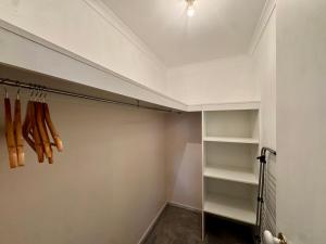 a walk in closet with white walls and shelves at Private Farmhouse & Paddock Available in Werribee South