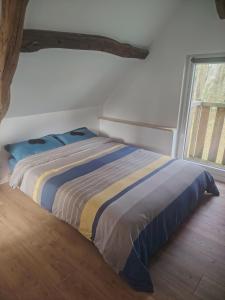 ein Schlafzimmer mit einem Bett in einem Zimmer mit einem Fenster in der Unterkunft Maisonnette au calme 