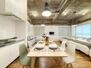 une cuisine et une salle à manger avec une table et un lit dans l'établissement b hotel Nikke - 1BR Apt for 10ppl near Hondori Shopping, à Hiroshima