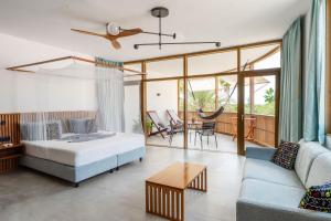 a bedroom with a bed and a living room with a couch at King Fisher Village Eco-Boutique Hotel in Tarrafal