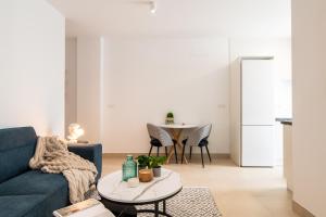 a living room with a blue couch and a table at Iberos Home in Seville