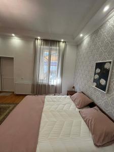 a large white bed in a bedroom with a window at Apartment 9 in Mtskheta