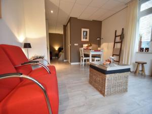 un salon avec un canapé rouge et une table dans l'établissement Alluring Apartment in Bergen with Terrace, Garden and BBQ, à Bergen