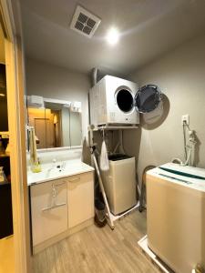 a bathroom with a sink and a microwave at 久松の宿 in Miyako-jima