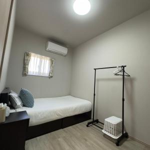 a small bedroom with a bed and a lamp at 久松の宿 in Miyako-jima