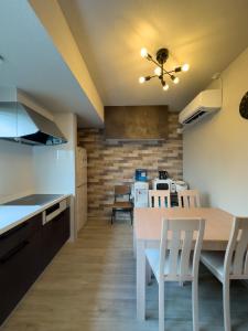 a kitchen and dining room with a table and chairs at 久松の宿 in Miyako-jima