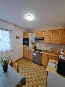 a kitchen with wooden cabinets and a sink and a table at Résidence le château Kaysersberg in Kaysersberg