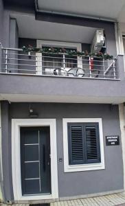 a grey building with a balcony and a door at Apartment Debrova in Alexandroupoli +35 photos