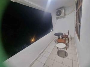 Habitación con mesa, sillas y pared negra. en Mulia Legian guest house, en Seminyak