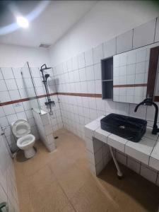 un baño con inodoro y lavabo en Mulia Legian guest house, en Seminyak