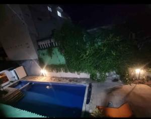 una vista de una piscina por la noche en Mulia Legian guest house, en Seminyak