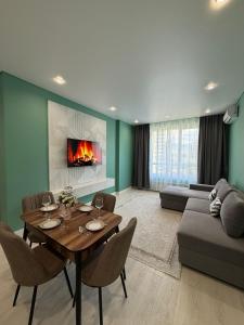 ein Wohnzimmer mit Tisch und Couch in der Unterkunft Светлая и уютная квартира с видом на горы, рядом с ТРЦ in Almaty + 38 Fotos