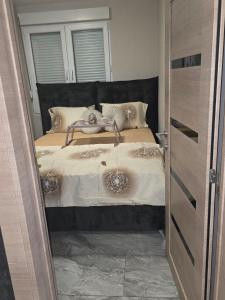 Schlafzimmer mit einem Bett und einer offenen Tür in der Unterkunft Apartman Warm nest in Kraljevo