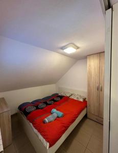 a bedroom with a bed with a red blanket at Studio - Apartmani 3 in Jošanička Banja