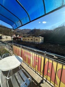 a table and chairs on a balcony with a train at Studio - Apartmani 3 in Jošanička Banja