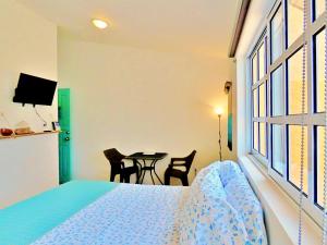 a bedroom with a bed and a table with chairs at Casa Brisamar , Studios in Puerto Morelos