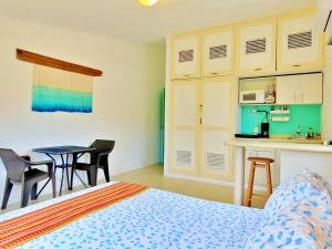 a bedroom with a bed and a table and chairs at Casa Brisamar , Studios in Puerto Morelos