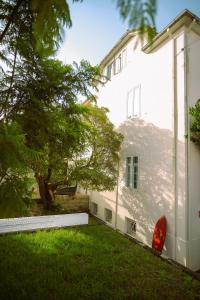 een wit huis met een boom in de tuin bij Porto Surf Lodge in Porto