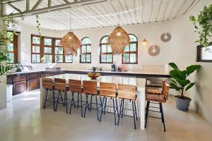 Una cocina con una gran isla con taburetes de bar. en Oceana Beachfront Lux 6BR Retreat Villa Private Yoga Shala, en Mal País