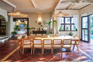 Un comedor con una gran mesa y sillas de madera. en Oceana Beachfront Lux 6BR Retreat Villa Private Yoga Shala, en Mal País