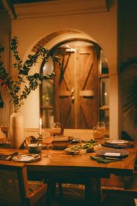 Una mesa de madera con copas de vino y una puerta. en Oceana Beachfront Lux 6BR Retreat Villa Private Yoga Shala, en Mal País 29 fotos más