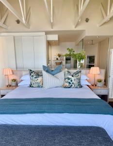 a large bed with pillows on it in a bedroom at Clifton 4th Beach Villa 6 Sleeper in Cape Town