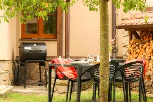 una mesa y sillas bajo un árbol en un patio en Chalupa s vlastním koupáním a rozlehlou zahradou, en Varvažov