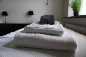 - deux serviettes empilées au-dessus d'un lit dans l'établissement Vannebodagatan, à Frövi