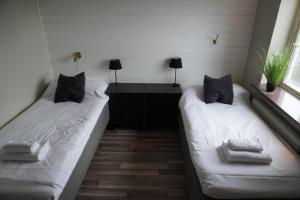 deux lits dans une chambre avec deux fenêtres dans l'établissement Vannebodagatan, à Frövi 2 autres photos