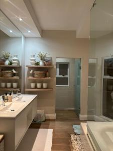 a bathroom with a tub and a sink and a shower at Clifton 4th Beach Villa 6 Sleeper in Cape Town