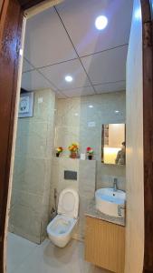 un baño con inodoro y lavabo en Comfystays, en Greater Noida