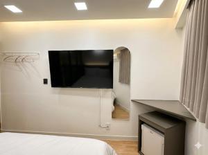 a bedroom with a flat screen tv on the wall at Hotel CF in Seoul
