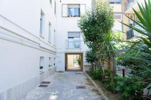 Promo Natale, Esclusiva Struttura Fronte Mare, Vicino al Centro Città في بيسكارا: ممر في مبنى سكني مليء بالنباتات